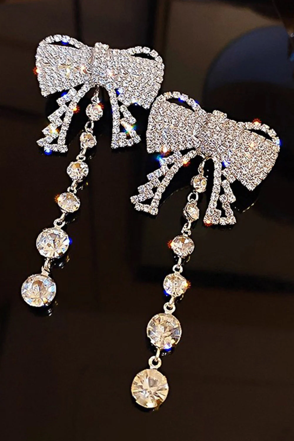 Boucles d’oreilles tombantes de bal en nœud argenté scintillantes en nœud d’appui.